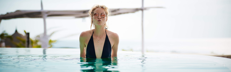 blonde woman in pool wearing sunglasses